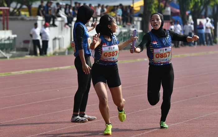 Pelari Kota Salatiga Liviana Rizki saat memberikan tongkat ke rekan setimnya, Kalila Annora, saat  f